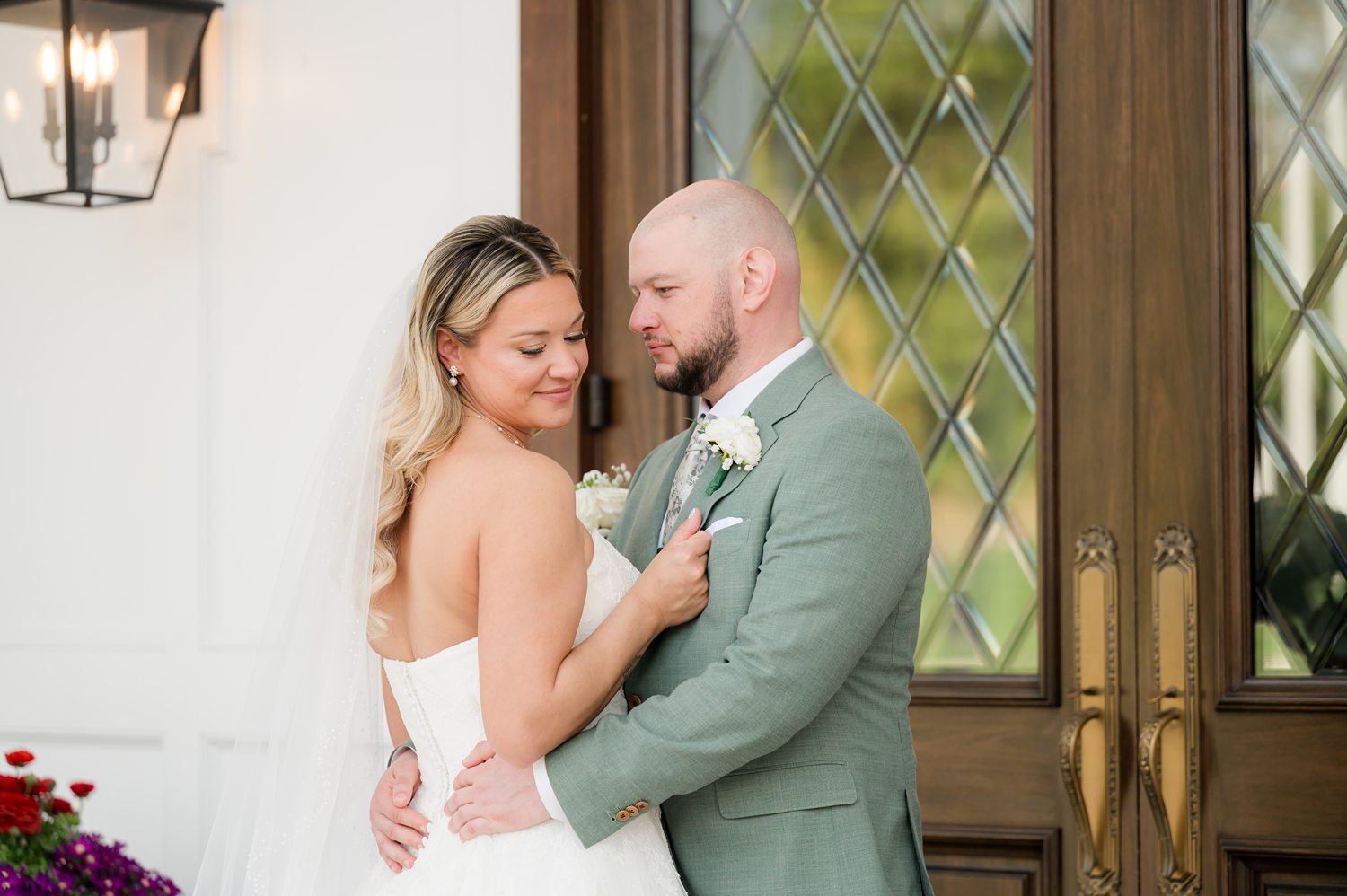 Romantic couple portrait at venue entrance with elegant wedding attire