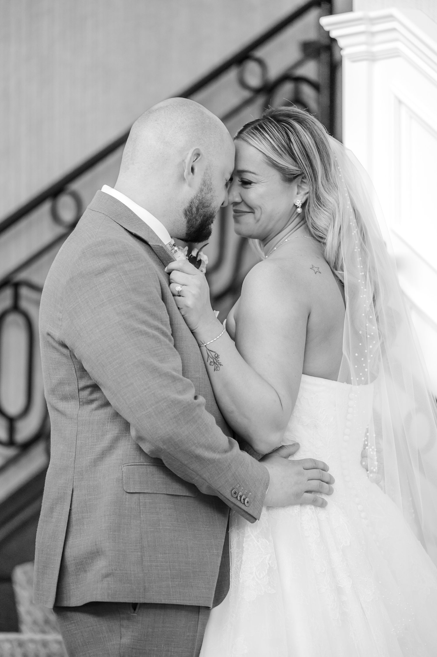 Black and white close-up portrait of bride and groom embracing indoors