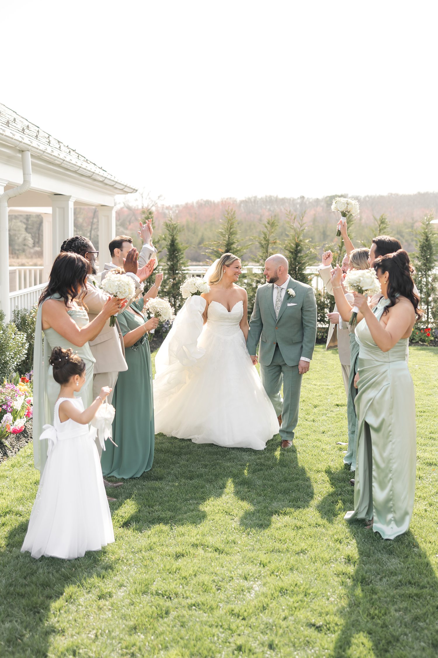Bride and groom celebrating with wedding party during outdoor ceremony entrance