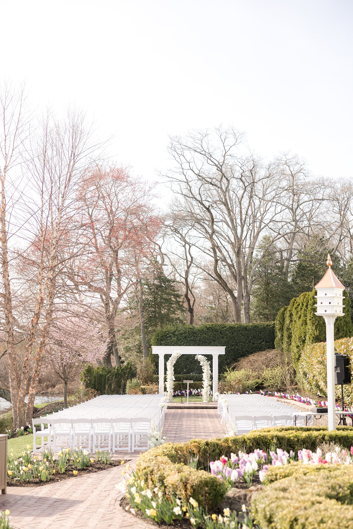 Beautiful outdoor garden wedding ceremony setup with floral gazebo and pathways
