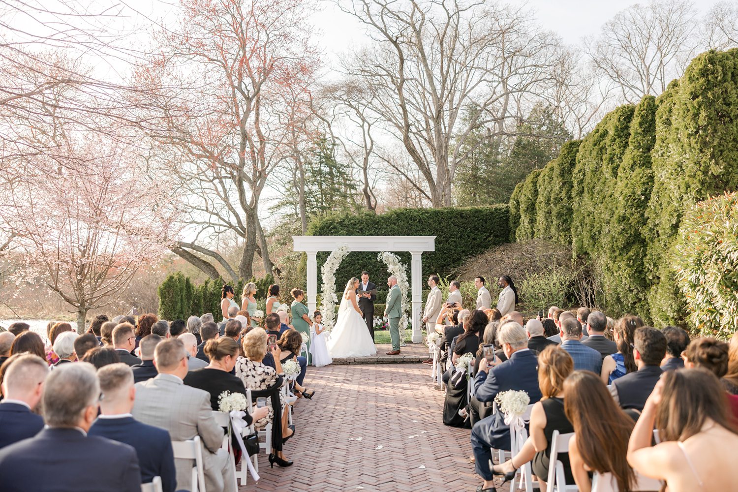 Wide view of guests seated at luxury outdoor garden wedding ceremony