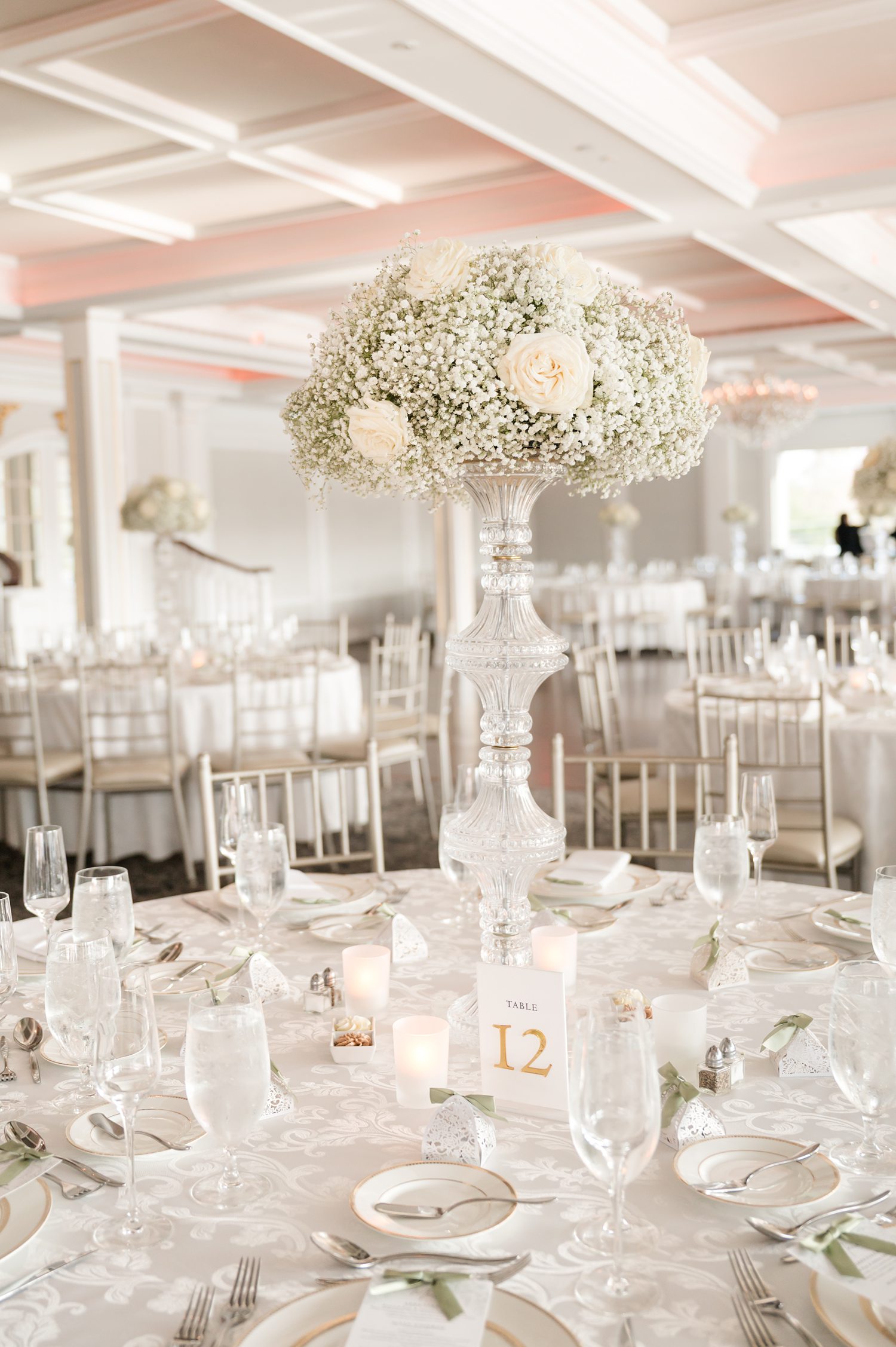 Sophisticated wedding reception table settings with tall white floral arrangements
