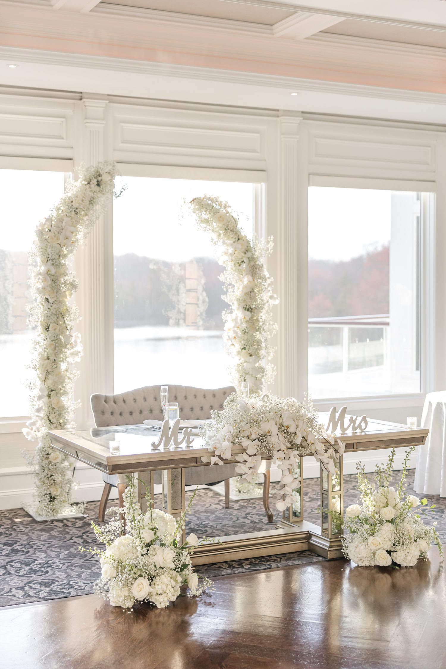 Bright wedding reception room with elegant white floral table settings