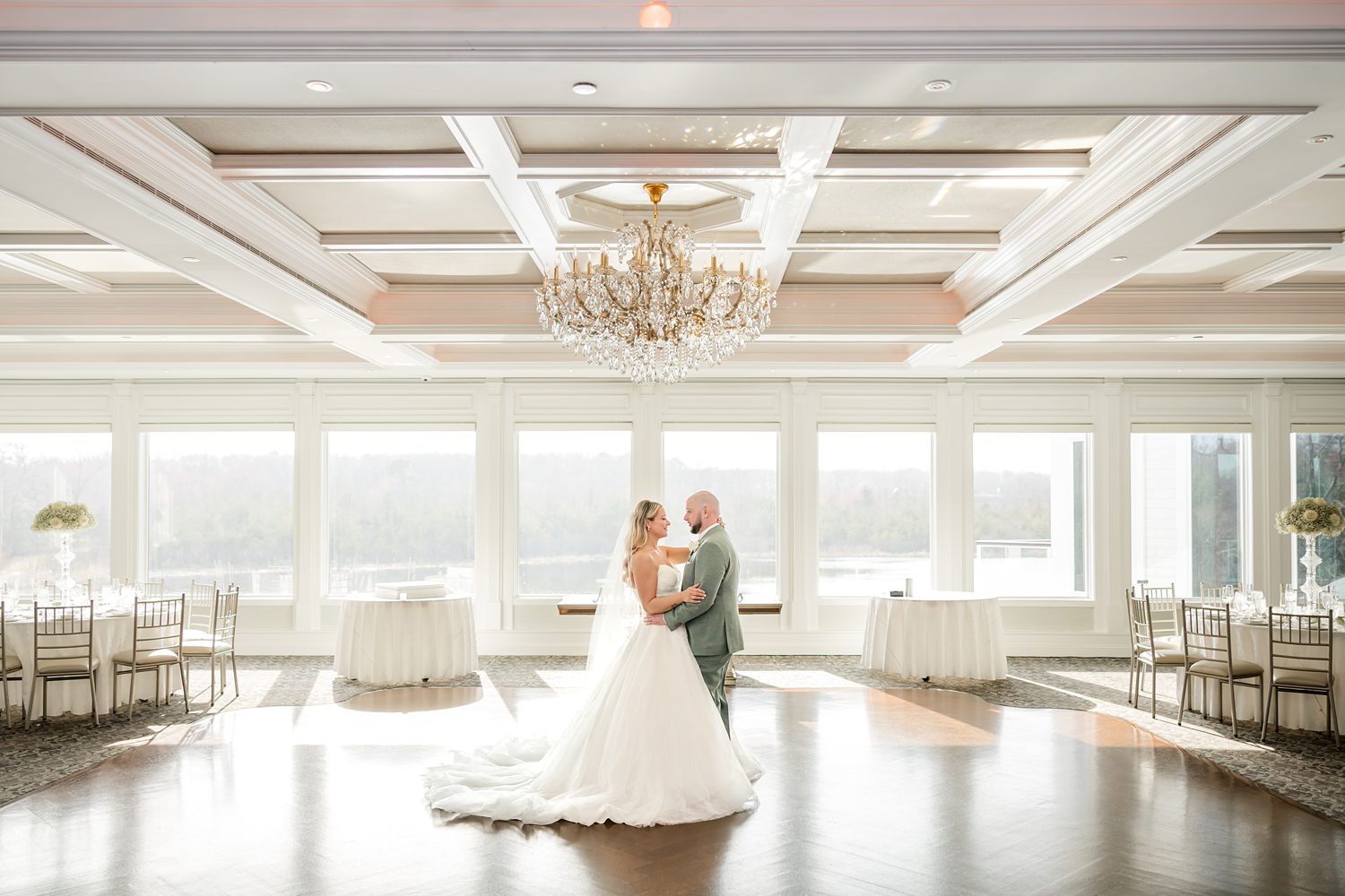 Romantic newlywed couple dancing alone in luxury wedding reception hall