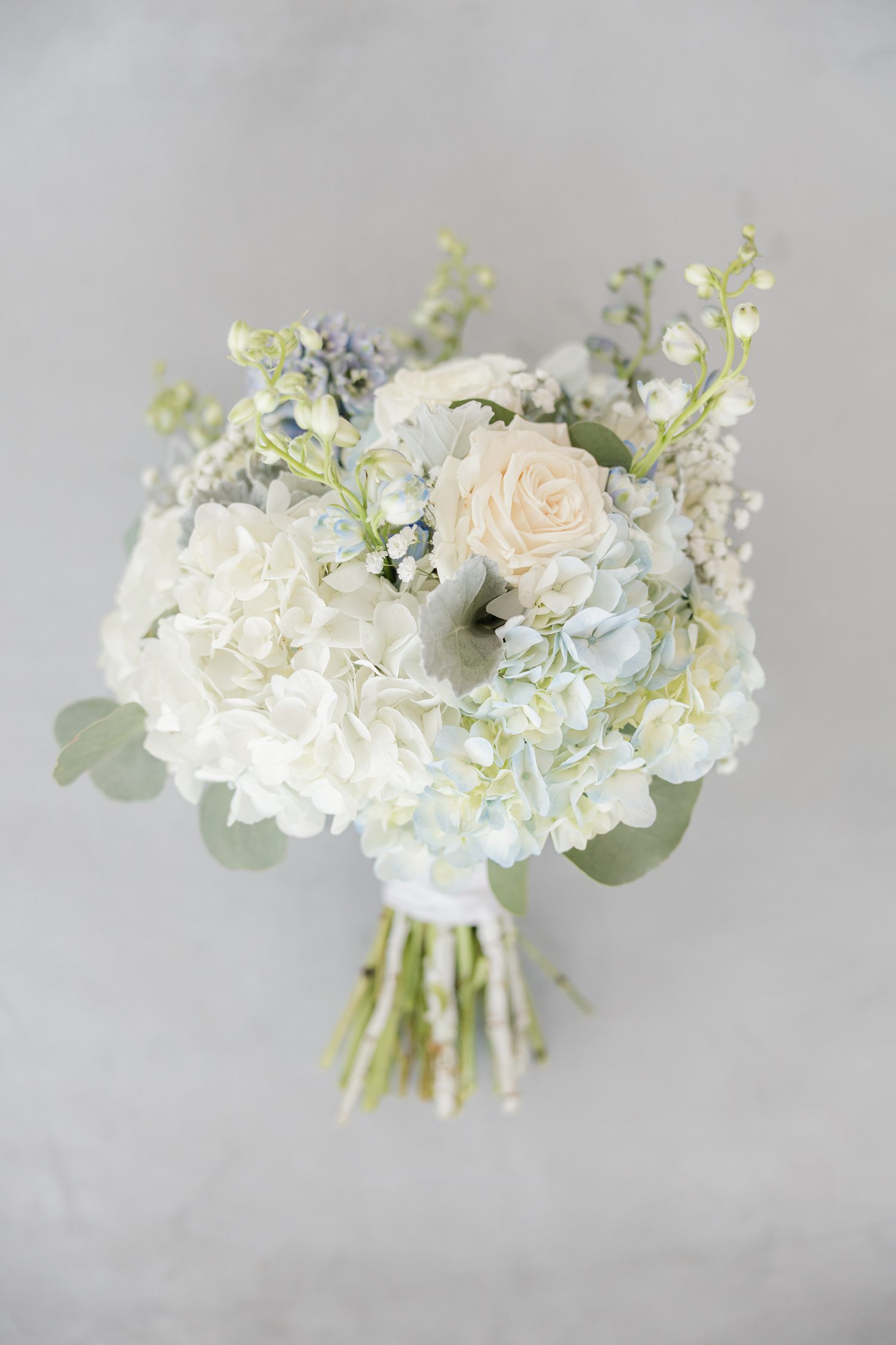 White and blue bridal bouquet on gray background 