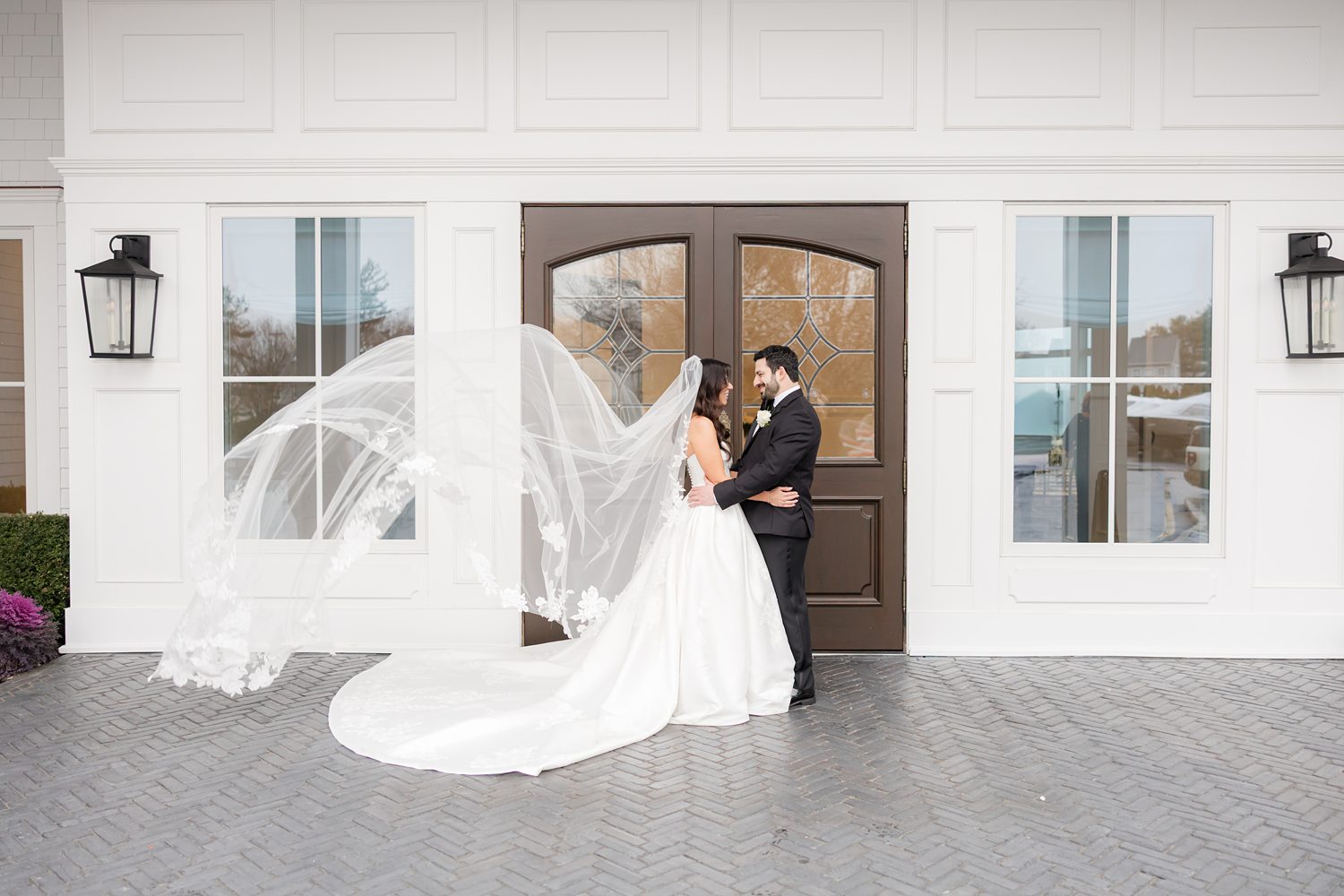 Bride and groom face to face outside the white entrance of Clarks Landing Yacht Club