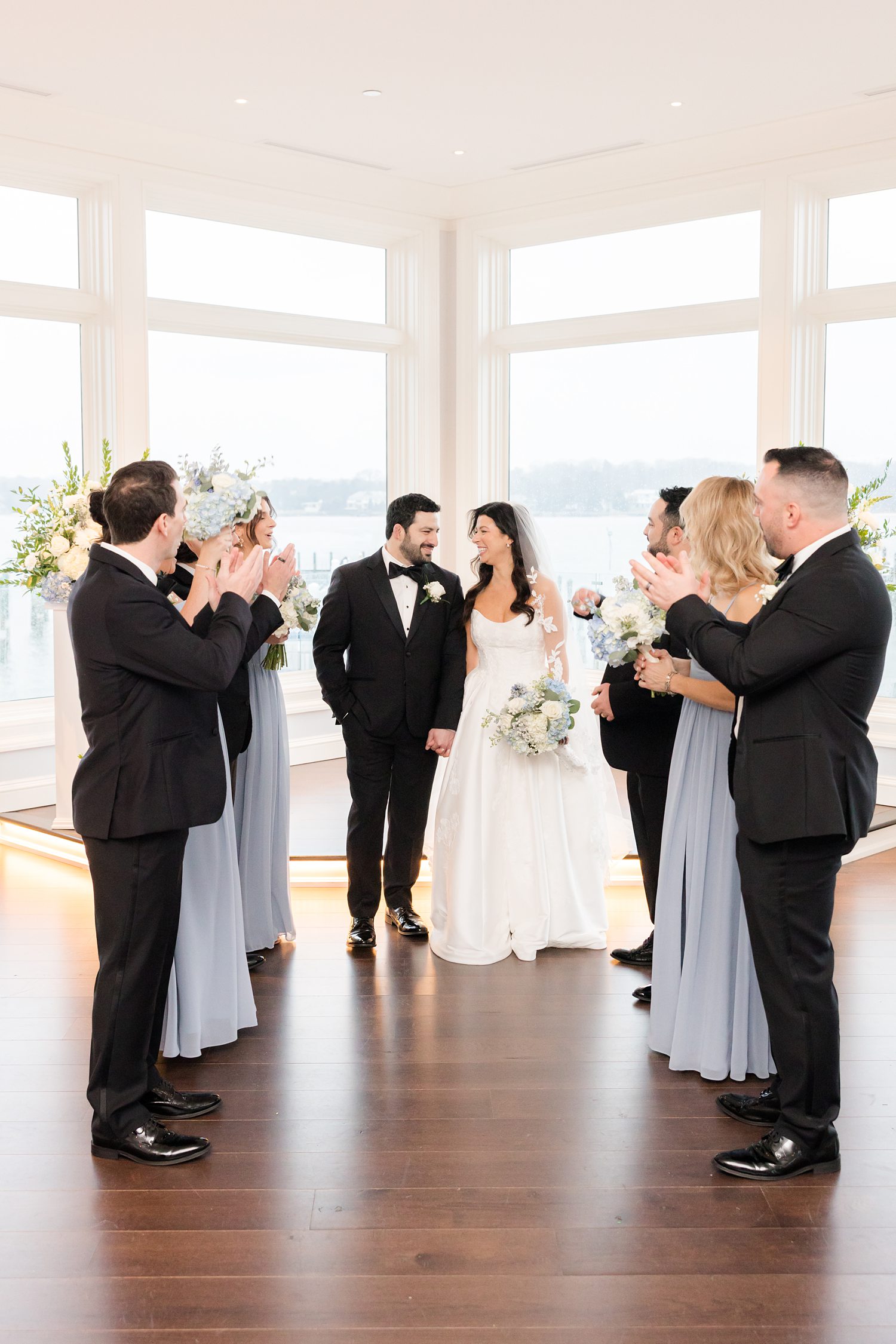 Wedding party gathered around the couple before the ceremony