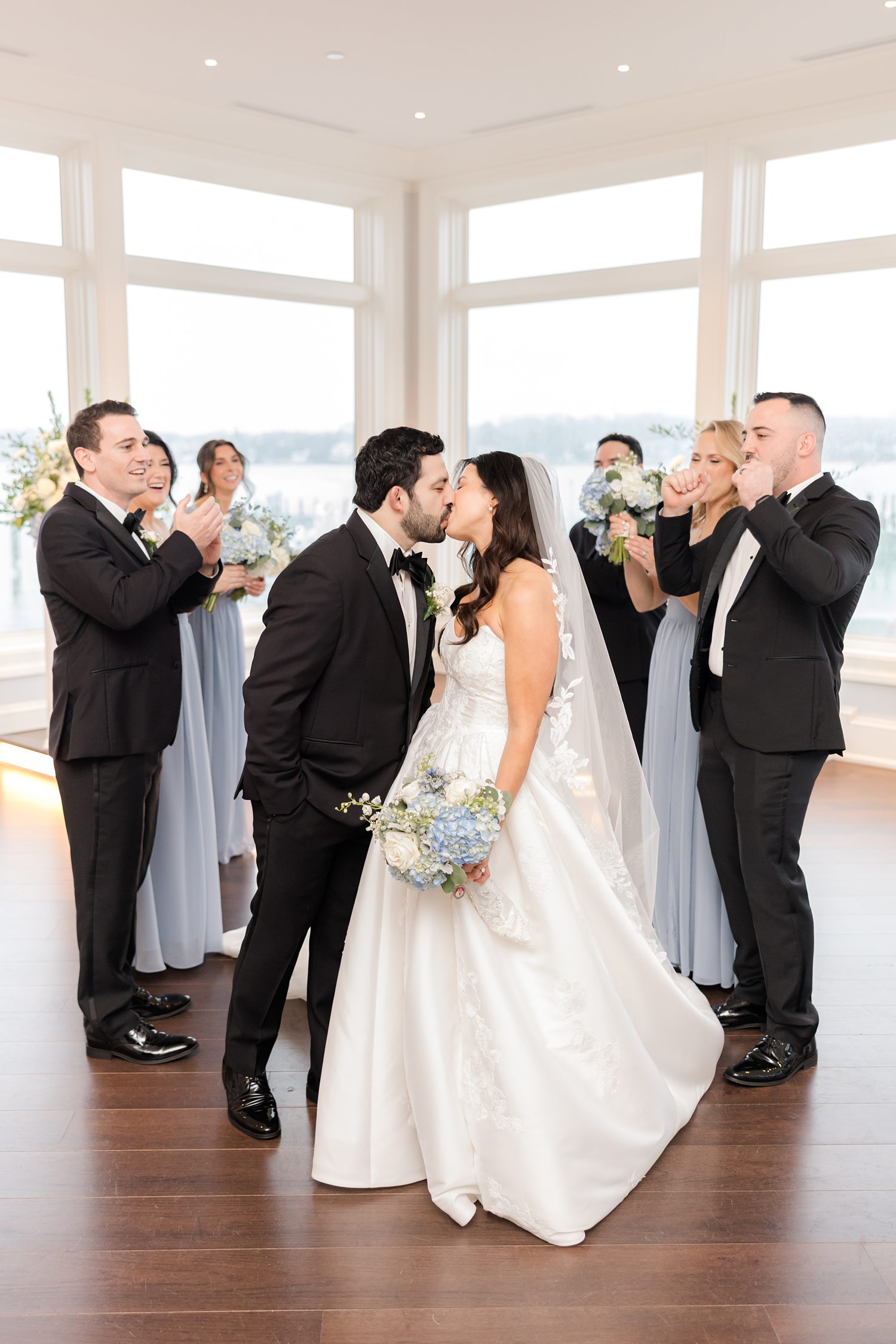 Wedding party cheering the couple during while kissing at Clarks Landing Yacht Club ceremony space