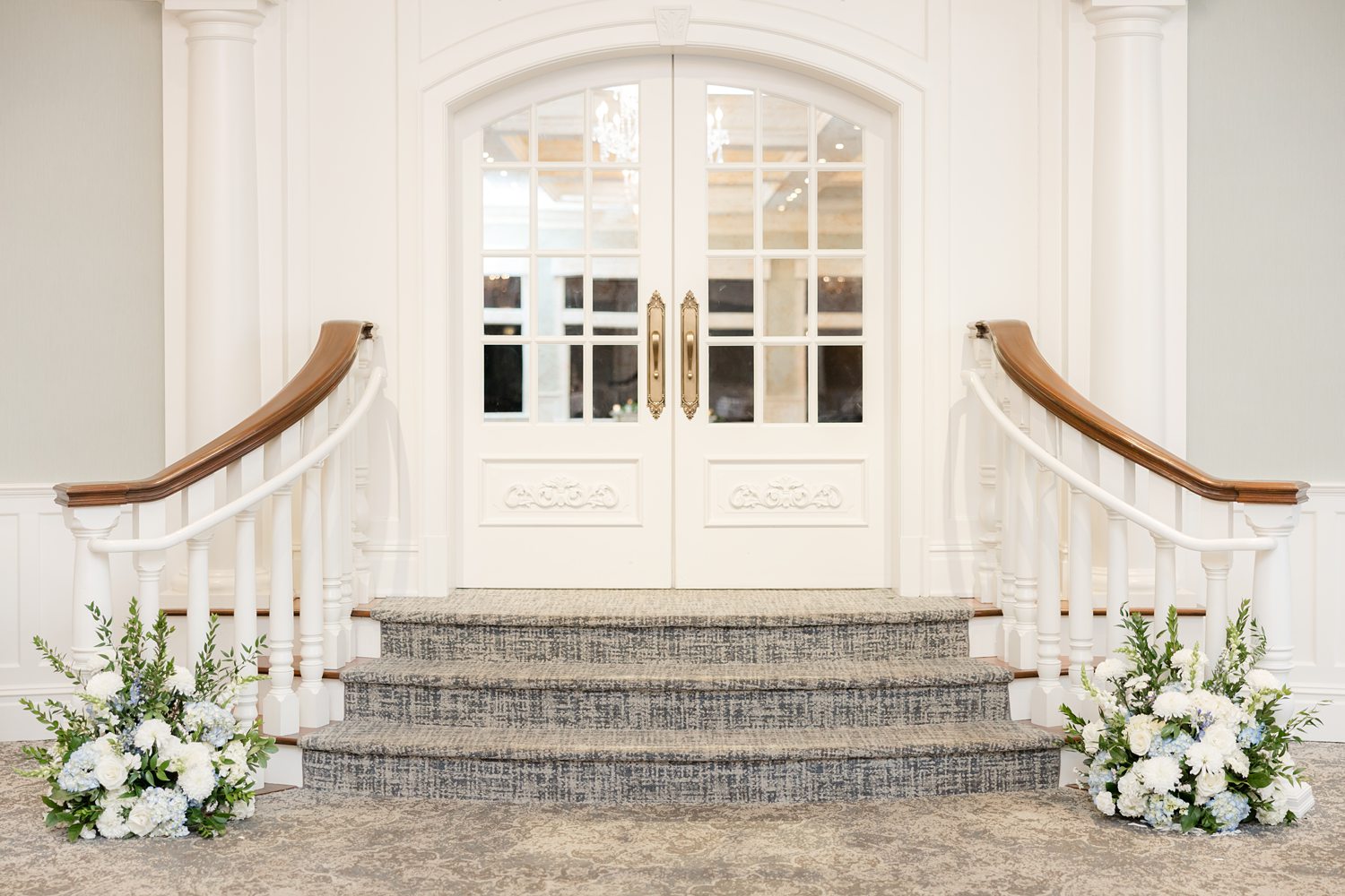 White entrance stairs decorated with ceremony flowers at Clarks Landing Yacht Club