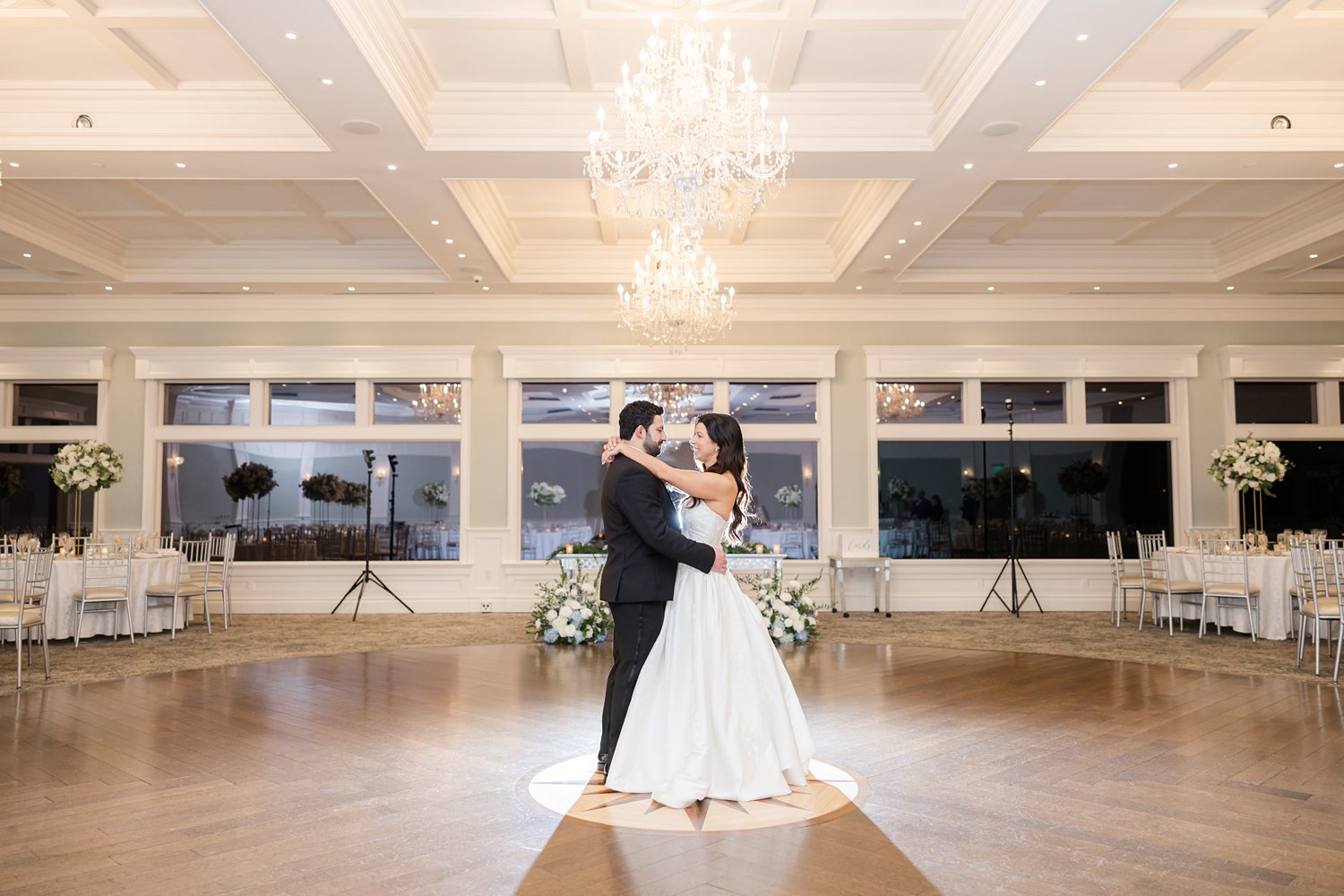 Bride and groom practice first dance in an empty ballroom