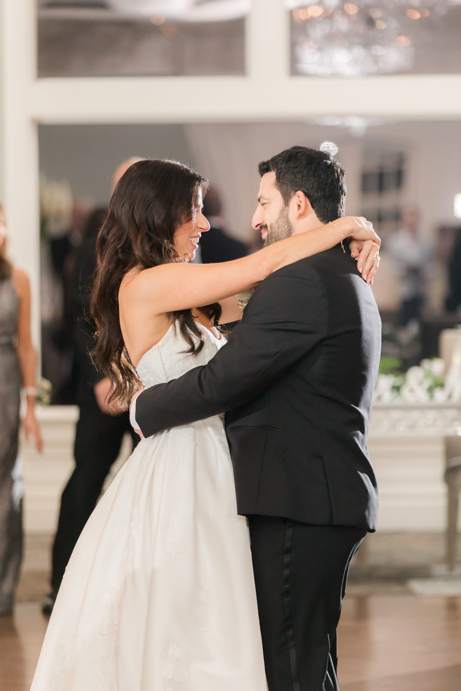 Bride and groom smiling at each other during their first dance at the reception