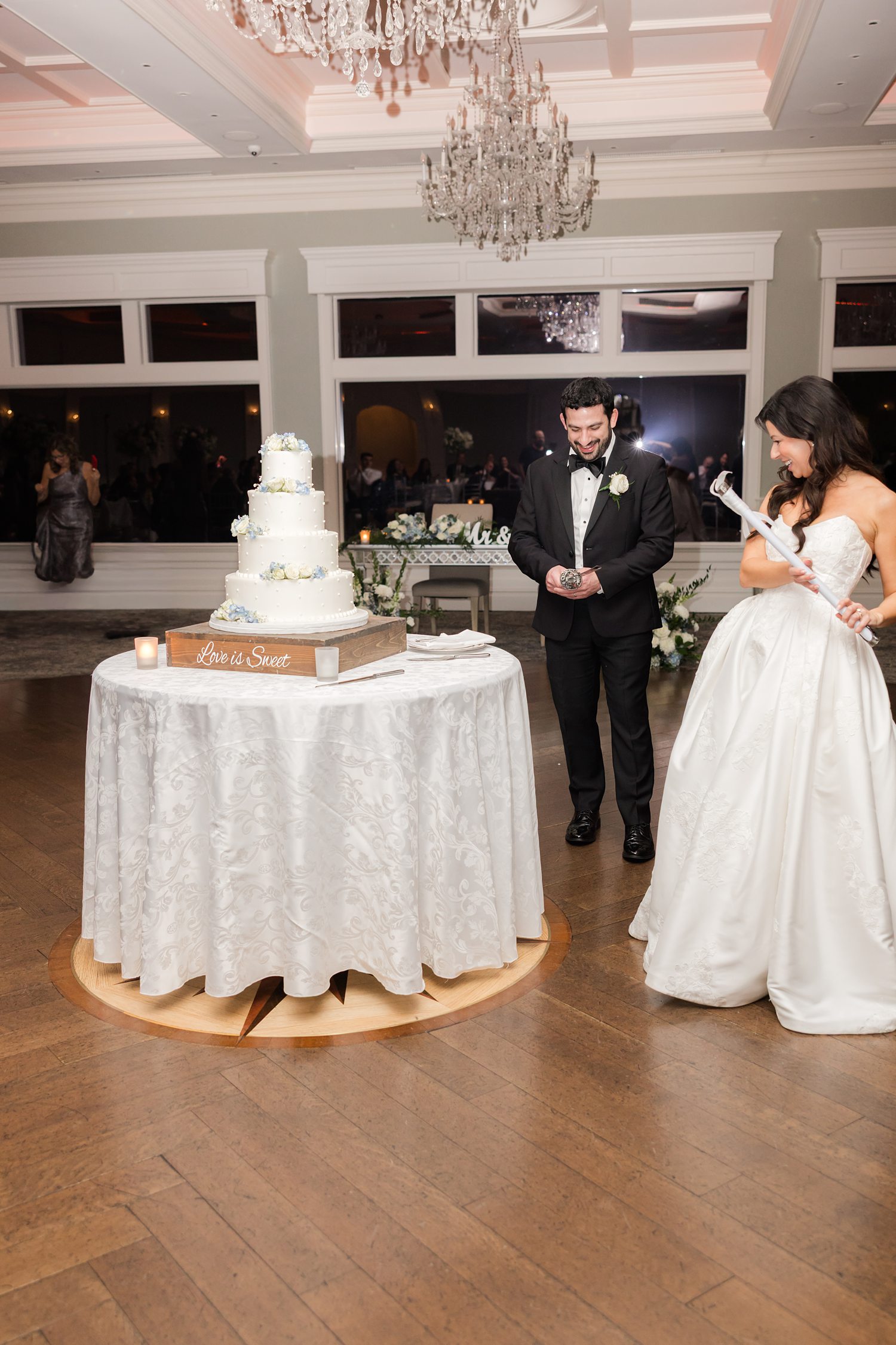 Bride and groom standing near their wedding cake before cake cutting