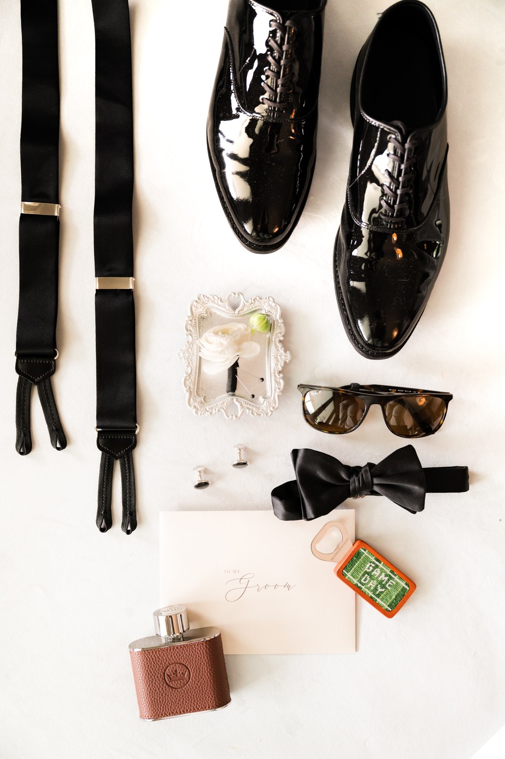 Groom's details flat lay with bow tie, suspenders,