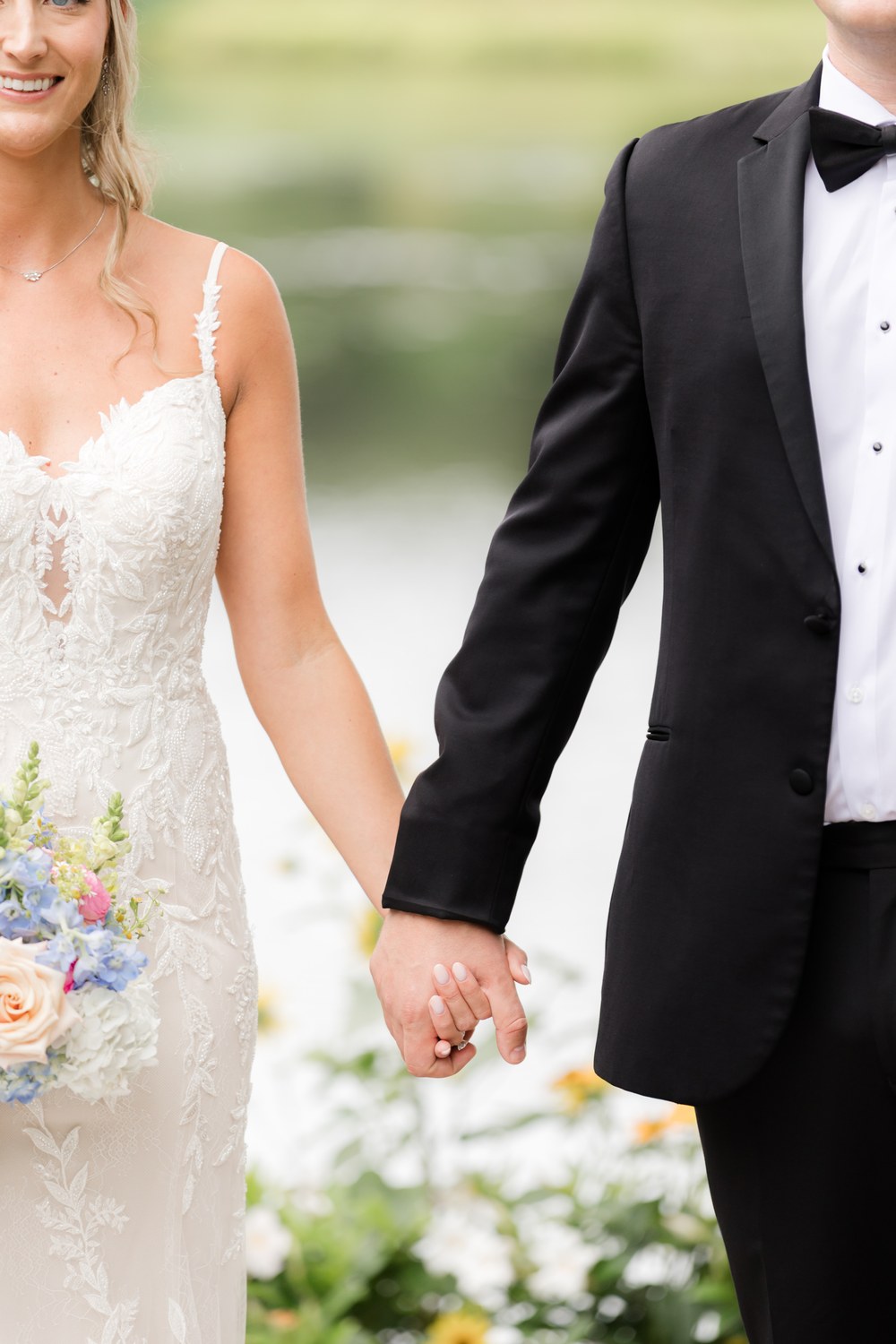 Close-up of the bride and groom holding hands at The Mill Lakeside Manor