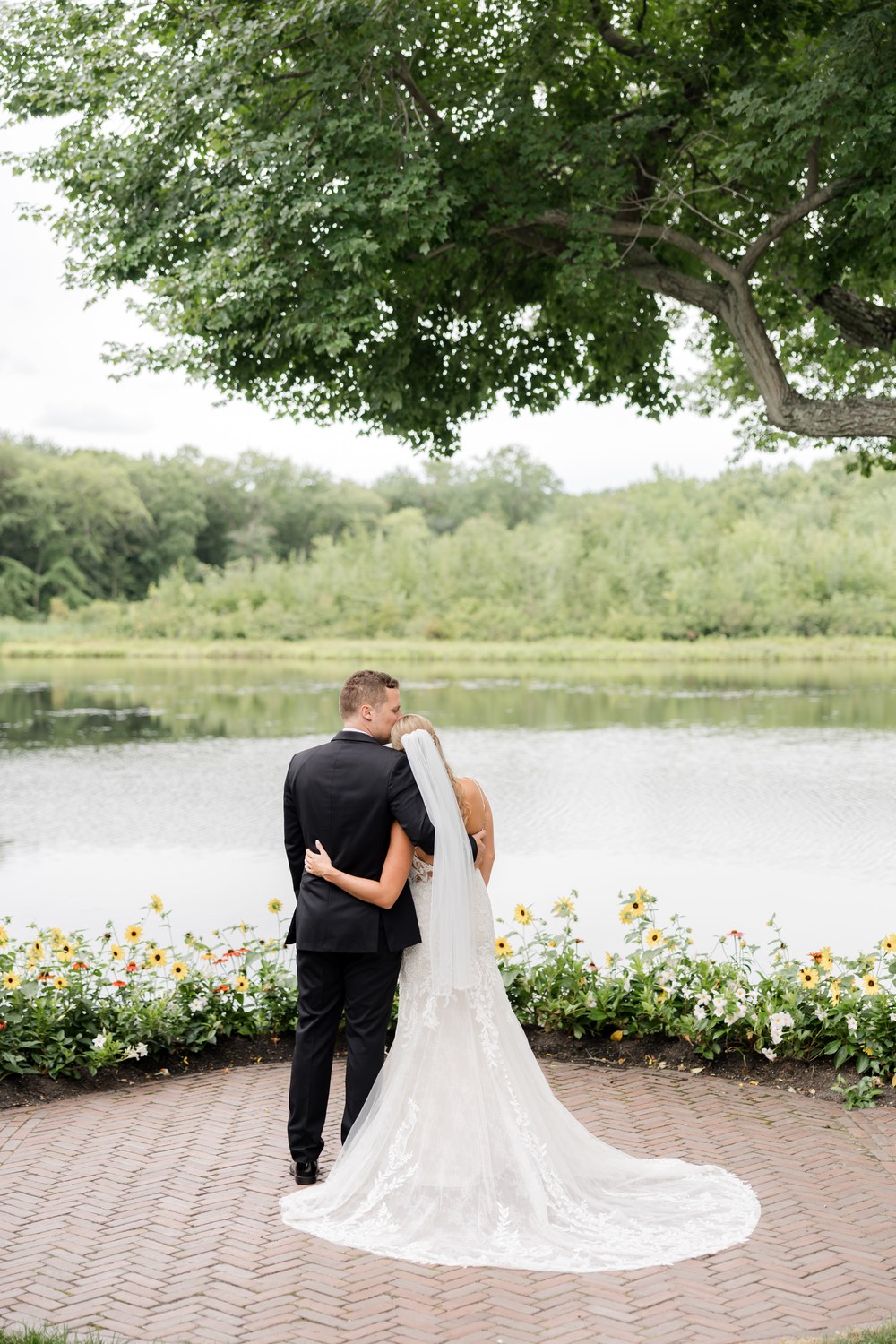 Bride and groom embracing by the lake at The Mill Lakeside Manor