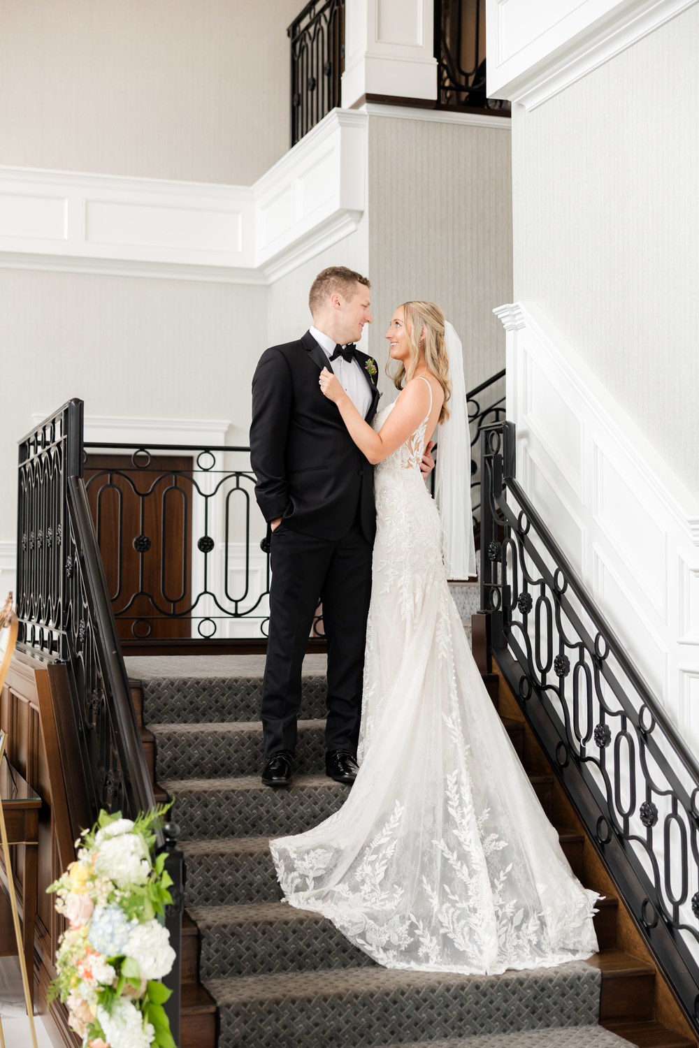 Bride and groom kissing on the grand staircase at The Mill Lakeside Manor
