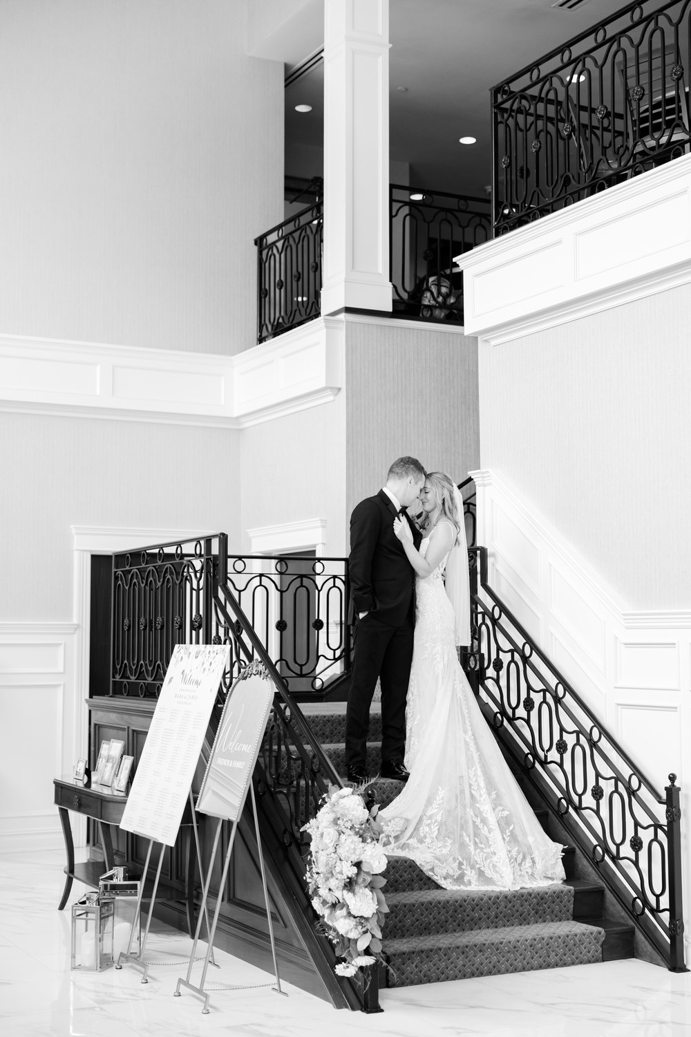 Black and white photo of the couple kissing on the staircase