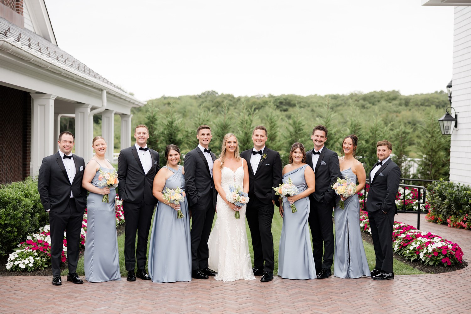 Full wedding party group photo on the brick patio at The Mill Lakeside Manor