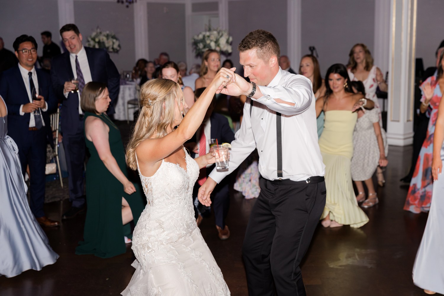 Wedding guests dancing under colorful lights at The Mill Lakeside Manor
