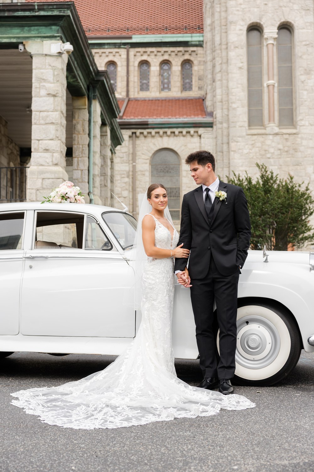 Romantic portrait of the couple leaning against the vintage car