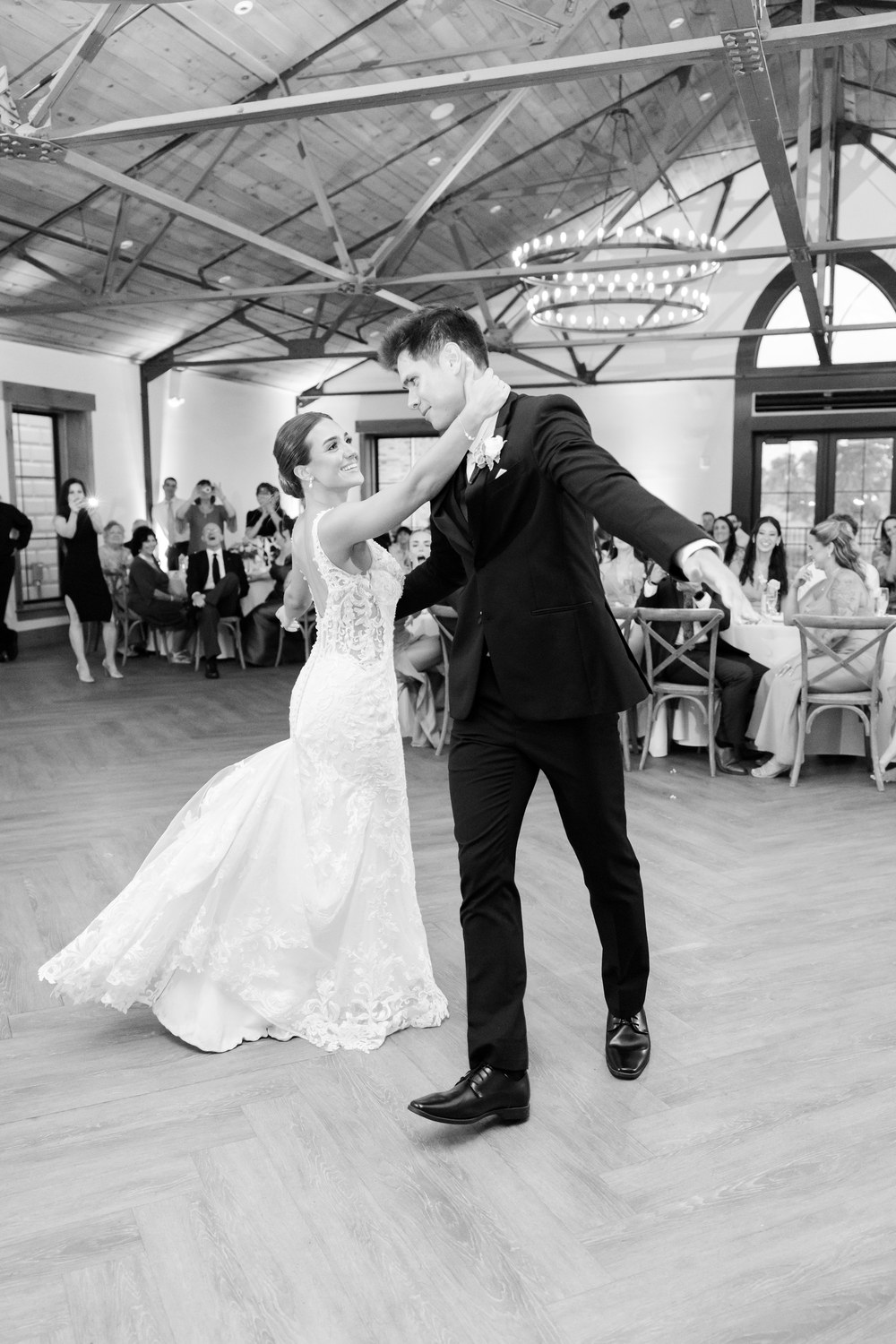 Black and white photo of the groom dipping the bride while dancing